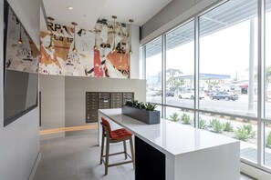 Enjoy a stylish space with a large window offering a view of the bustling street outside, a minimalist design, and a decorative wall piece.