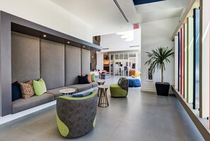 Relax in a spacious seating area with a sofa and comfortable chairs, surrounded by lush greenery.