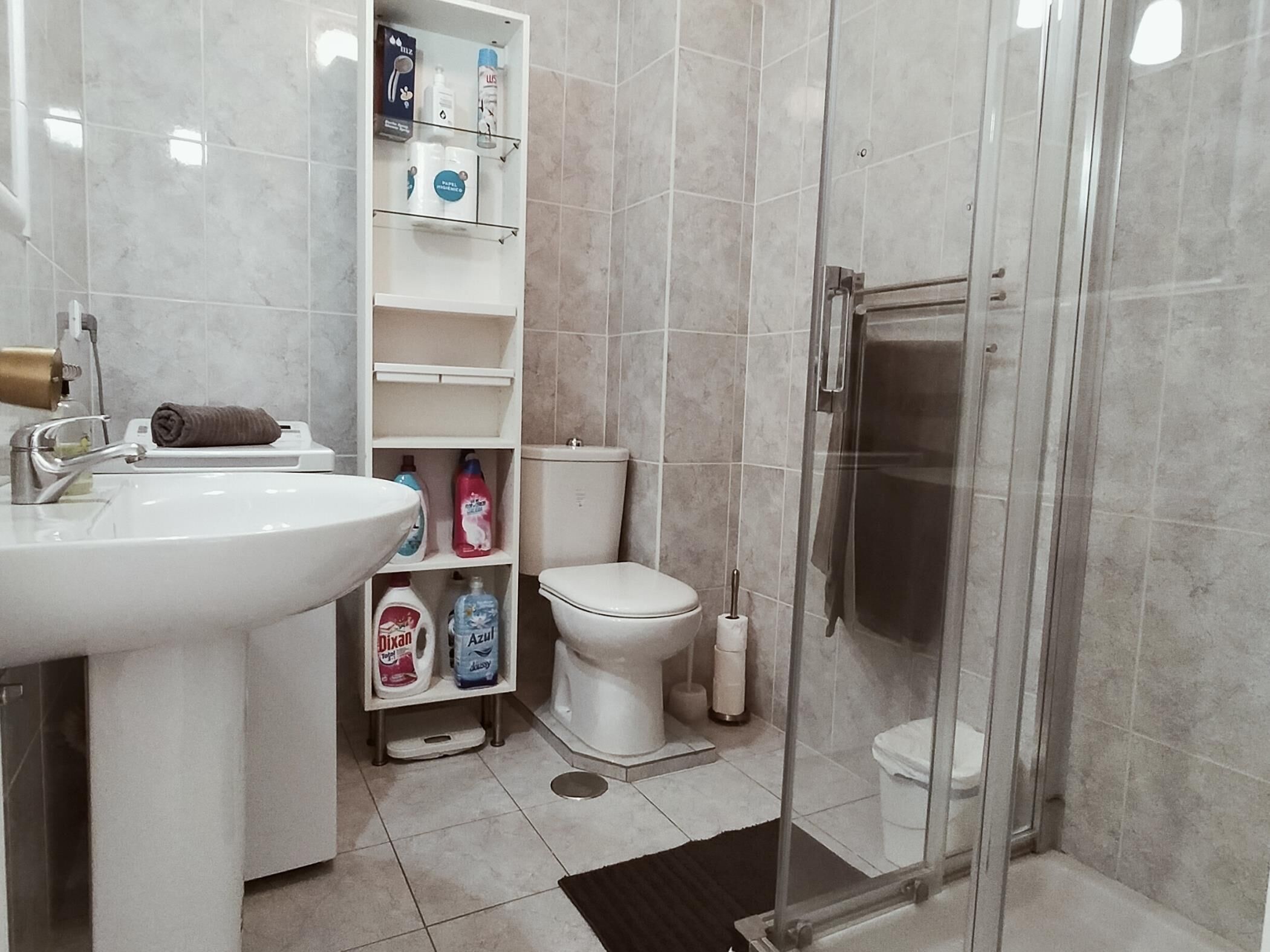 Un bagno con lavandino, WC e doccia vetrata.