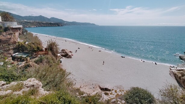 A beach with a clear view of the ocean and distant mountains. - Nerja Sun Apartment Bahía 17 (Nerja)