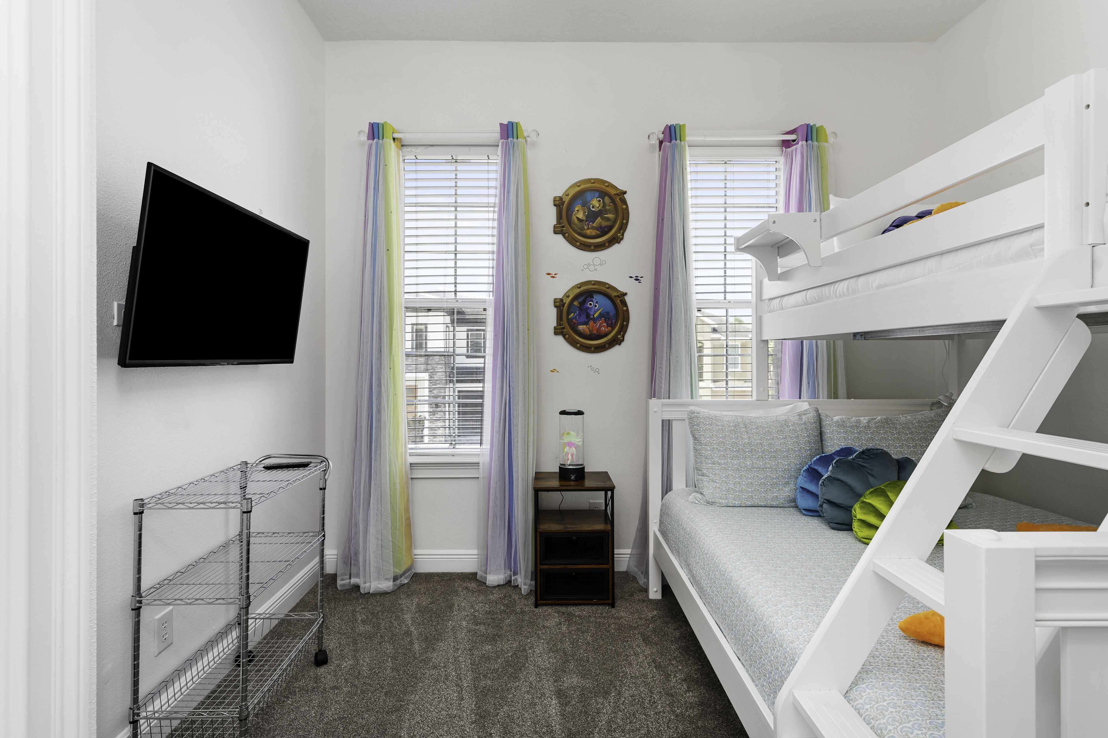A compact room with bunk beds, a TV, and a small table with a decorative item.
