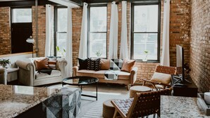 Ein gemütliches Wohnzimmer mit Backsteinwand, einer Couch, einem Couchtisch und einem Sessel.