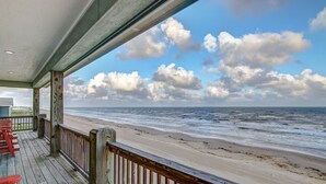 Une terrasse en bois offrant une vue sur la plage et l’océan.
