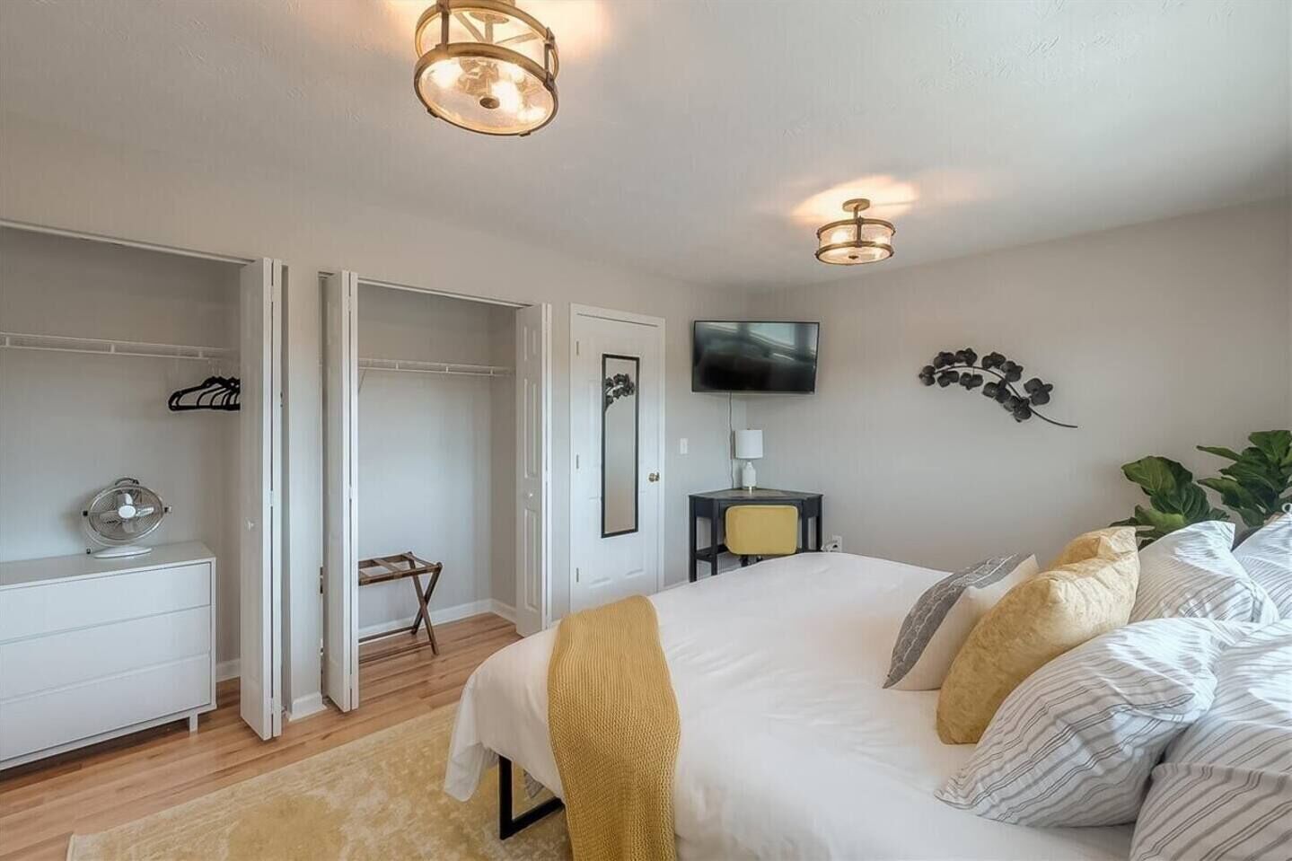 A bedroom with a bed, bedside table, TV, and a wardrobe.