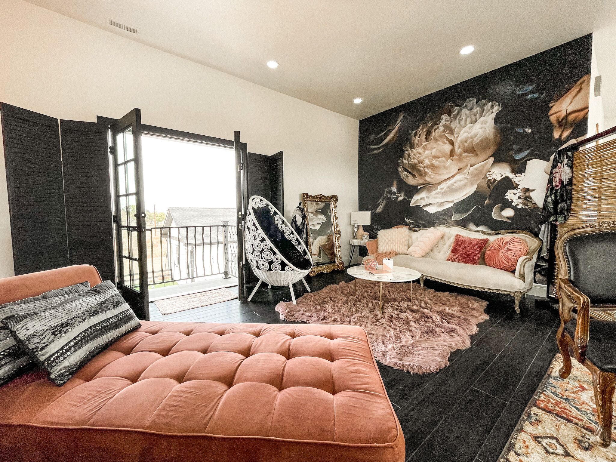 Una sala de estar moderna con un ventanal grande, un sofá, un sillón y un mural decorativo.