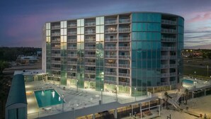 A modern hotel with multiple balconies, a rooftop pool, and a glass facade. - Top-Floor Condo - On the Beach - Gulf Views - Walk the Boardwalk (Biloxi)