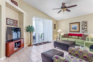 Relax in this stylish living room with a flat-screen TV, comfortable sofa, and beautiful artwork.