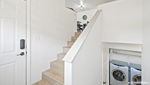 Eine Treppe führt zu einem Essbereich, an der Wand hängt eine Uhr.