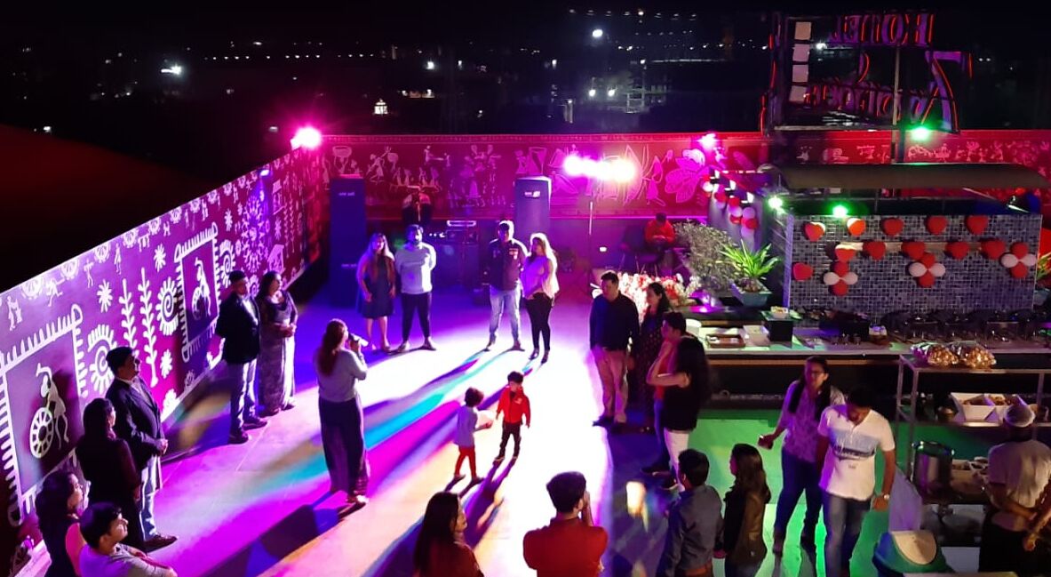 Un escenario con público, cabina de DJ y un decorado.