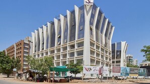 A modern building with a unique angular design, featuring multiple balconies and large windows.