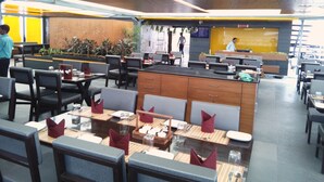 A modern restaurant with booths and tables, a counter, and a menu board.