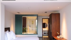 A modern hotel room with a large bed, a bathroom with a glass shower enclosure, and a wooden vanity. - Cochin Sang Hotel (Ho Chi Minh City)