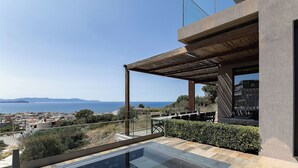 Une maison moderne dotée d’un grand balcon en verre offrant une vue imprenable sur la côte.