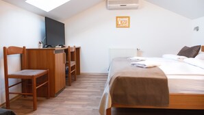 A bedroom with a bed, a desk, and a chair. - Romantic attic 1/3 room  (Izola)