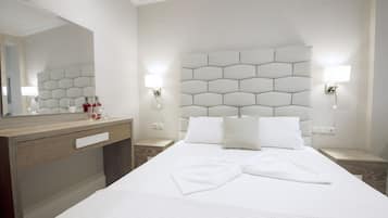 A hotel room with a large bed, a wooden dresser, a mirror, and two bedside lamps.