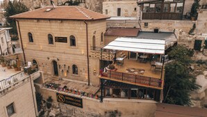 Un edificio con terraza y zona de estar al aire libre, con la leyenda "Sierra Cave Cappadocia".