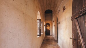 Un pasillo estrecho con arcos y suelo de madera.
