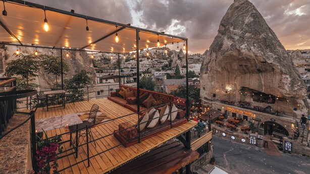 Terraza en la azotea con asientos y vistas a un paisaje montañoso.