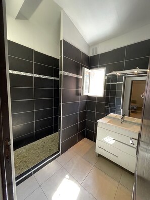 Bathroom features a sleek design with a white vanity, sink, and modern faucet.