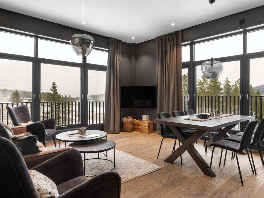 Een moderne woonkamer met een groot raam, een eethoek en een flatscreen-televisie.