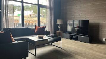 A modern living room with a sofa, coffee table, and TV.