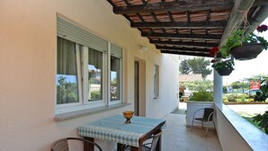 A covered patio with a table and chairs, a hanging plant, and a view of the street. - Apartment 1779/53709 (Istria - Banjole), 550m from the beach (Banjole)