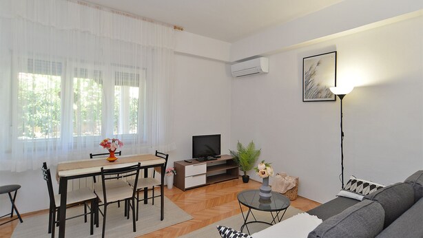 A modern living room with a dining area, a sofa, a TV, and a lamp. - Apartment 1779/53709 (Istria - Banjole), 550m from the beach (Banjole)