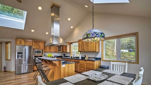 A modern kitchen with wooden cabinets, stainless steel appliances, and a large island. - Idyllic Retreat ~ 20 Mi to Olympic National Park! (Port Angeles)