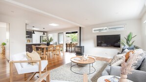 Un salón amplio con una mesa de comedor, sofás y una chimenea.
