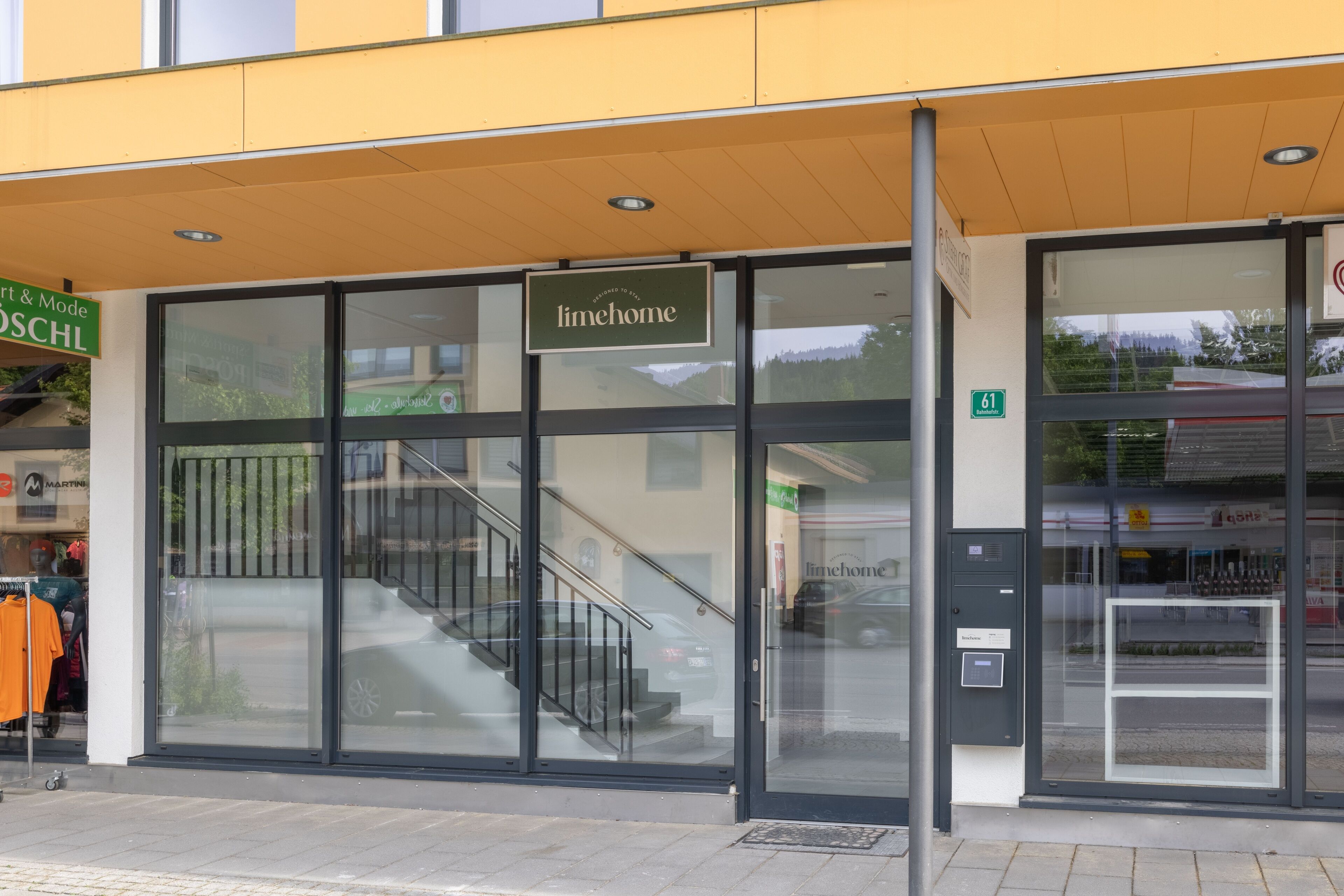 Een gebouw met een bord waarop 'limehome' staat en een trap naar een ingang.