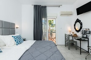 Relax in comfort with a large bed, desk, and sliding door to an outdoor seating area.