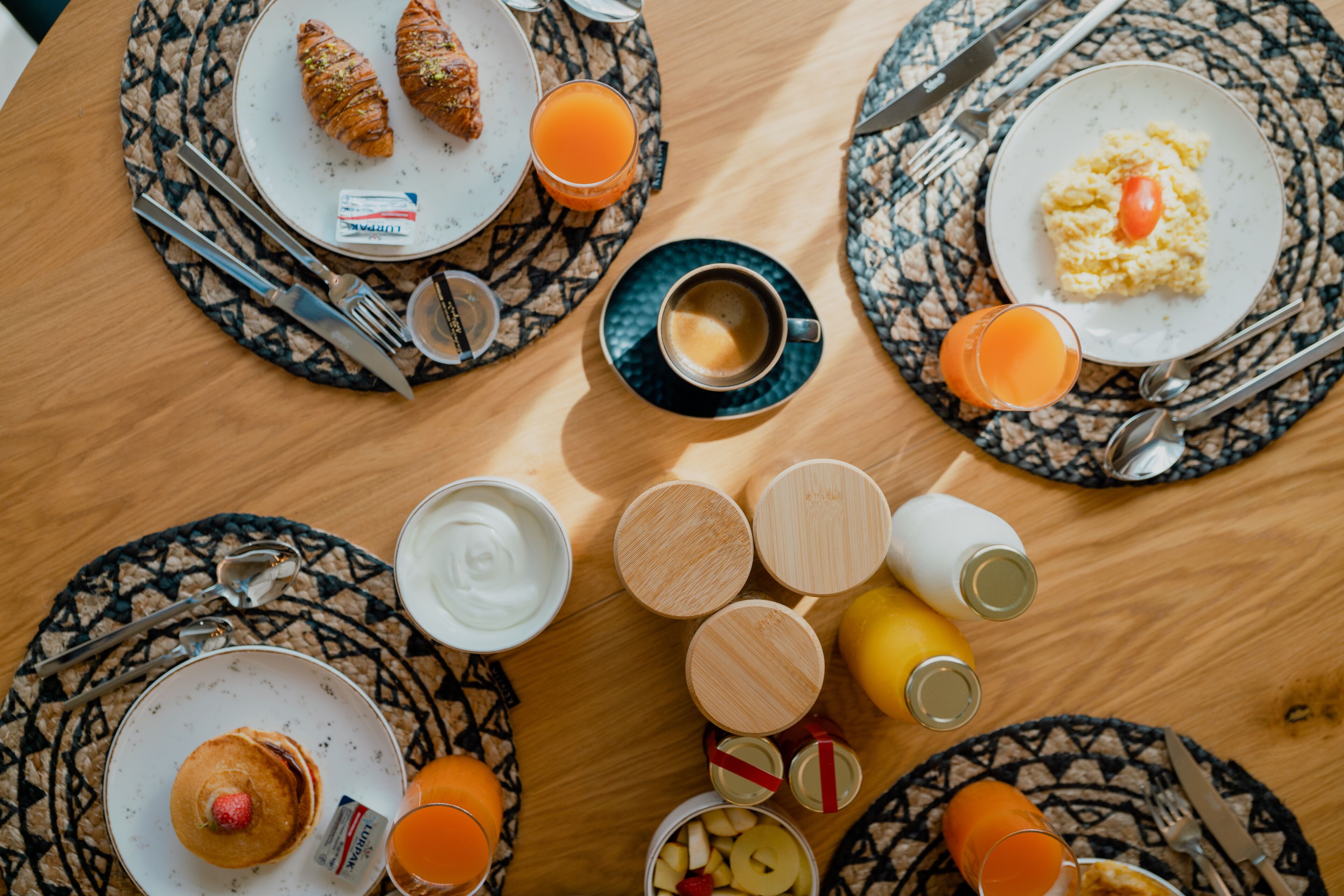 Ein Frühstückstisch mit Speisen, Getränken und Besteck.