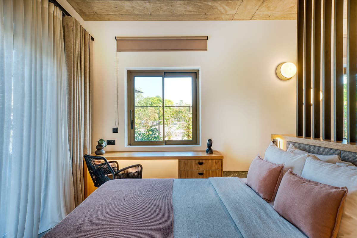 Un dormitorio con una cama, un escritorio y una silla.