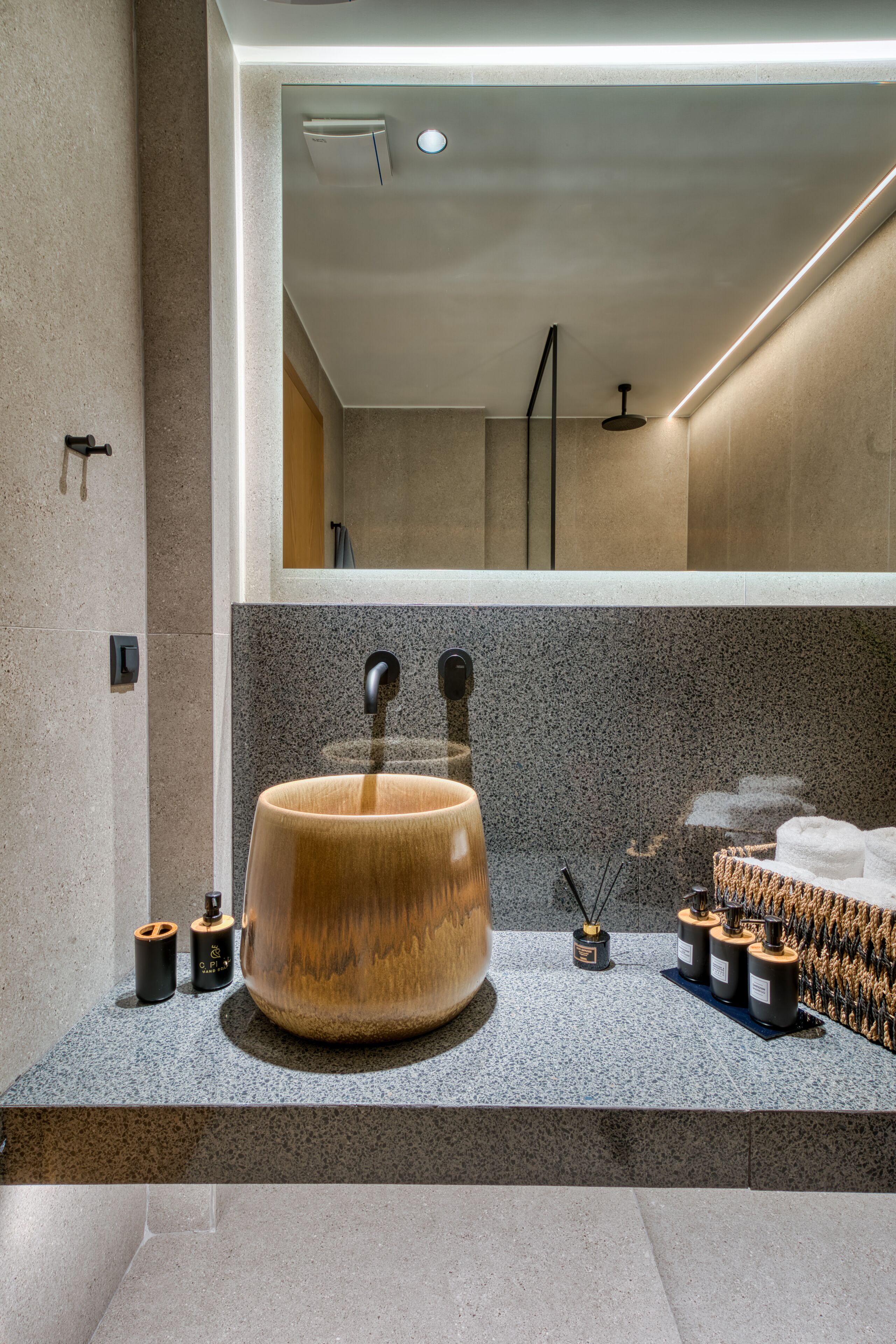Une salle de bain moderne avec un grand lavabo en bois, un miroir et un espace douche.
