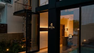 Un hôtel moderne avec une façade en pierre, de grandes baies vitrées et une piscine.