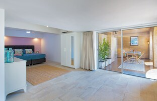 Un dormitorio moderno con cama, mesita de noche y un ventanal grande.