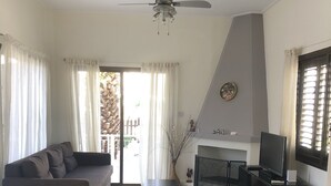 Een moderne woonkamer met een bank, een televisie en een haard.