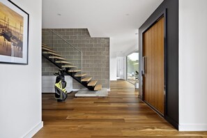 A modern interior with a wooden staircase, a brick wall, and a wooden floor. - Sunset on Moonah. (Fingal)
