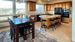 Una cocina amplia con una isla grande, armarios de madera y vistas al exterior.