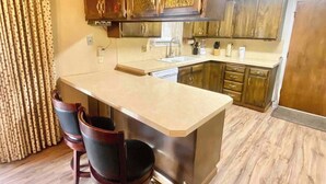 A modern kitchen with a central island, stainless steel appliances, and wooden cabinets. - Roomy Midtown Home-Large and Central to Everything (Pocatello)