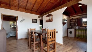 Un coin repas rustique, avec des meubles en bois, un lave-linge et une vue sur une autre pièce.