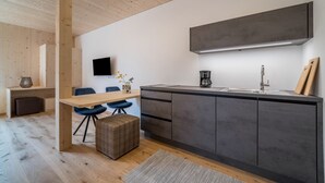 Une cuisine moderne avec un plafond en bois, un téléviseur à écran plat, une machine à café et un évier.
