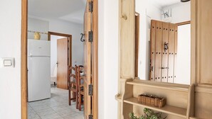 Eine Küche mit Kühlschrank, Holzschränken und einem Essbereich mit Stühlen.