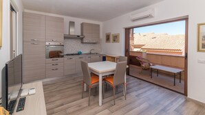 Cozinha moderna com área de refeições, TV e vista para o exterior.