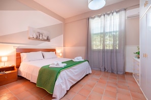 A hotel room with a bed, nightstand, and a wall-mounted artwork.