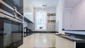 A modern kitchen with a Siemens oven, a sink, and a window with curtains.