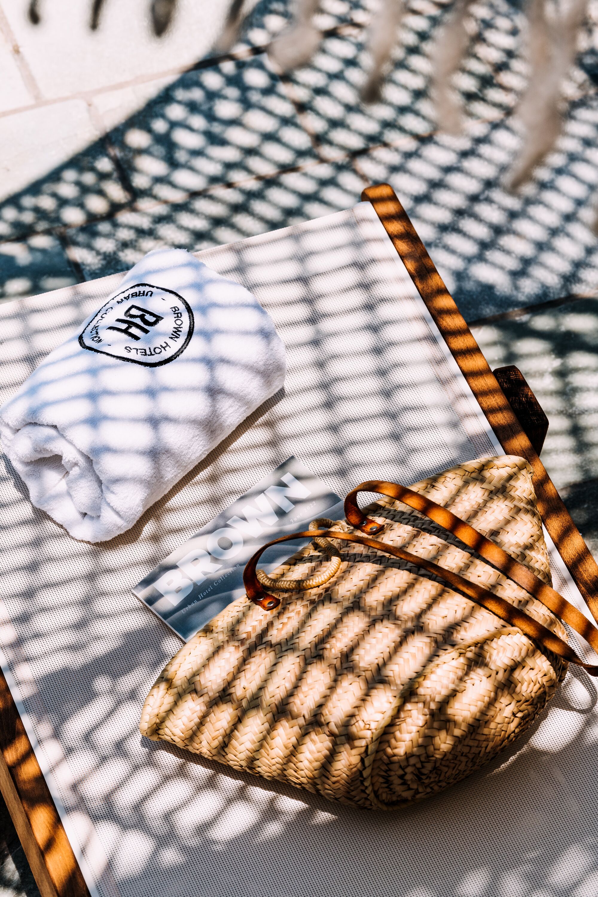 Una bolsa tejida y una toalla blanca con un logotipo sobre una superficie estampada.