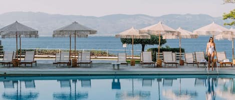 Una piscina al aire libre, sillones reclinables de piscina