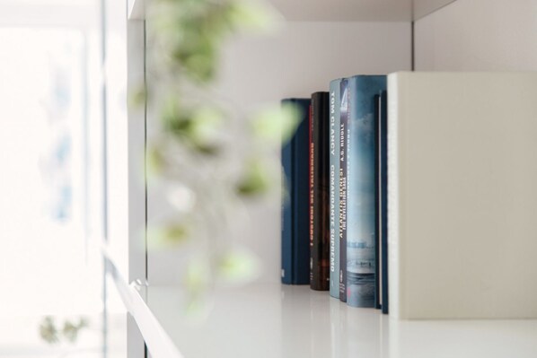 A bookshelf with books and a white cabinet.
