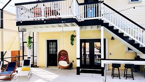 A poolside area with lounge chairs, a hanging chair, and a staircase leading to an upper deck. - ⛱  Spacious, Private Pool, Golf Cart - just RELAX  🏝 (Panama City Beach)
